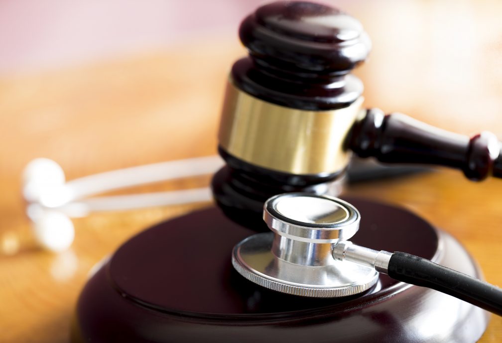 Medical law concept. Gavel and stethoscope on wooden table
